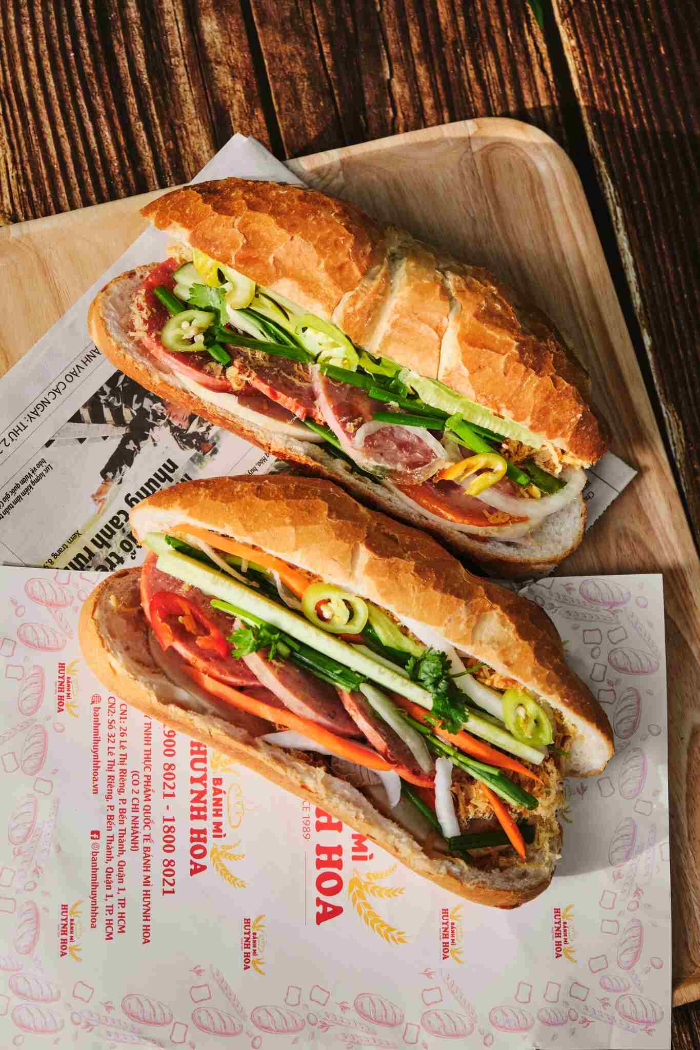 Quầy bánh mì vỉa hè Sài Gòn lúc 5 giờ sáng — bánh vừa ra lò, hàng khách dài và mùi nướng thơm phức khắp phố