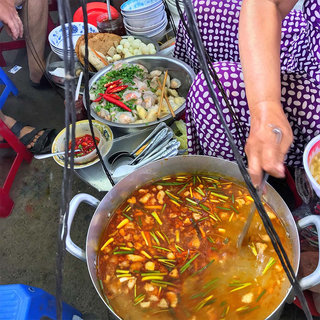 Tô bánh canh cá bà Trâu — sợi bánh canh dẹt dày trắng ngần trong nước dùng cá vàng trong, miếng cá bả trầu trắng ngọt và hành phi vàng ruộm trên mặt