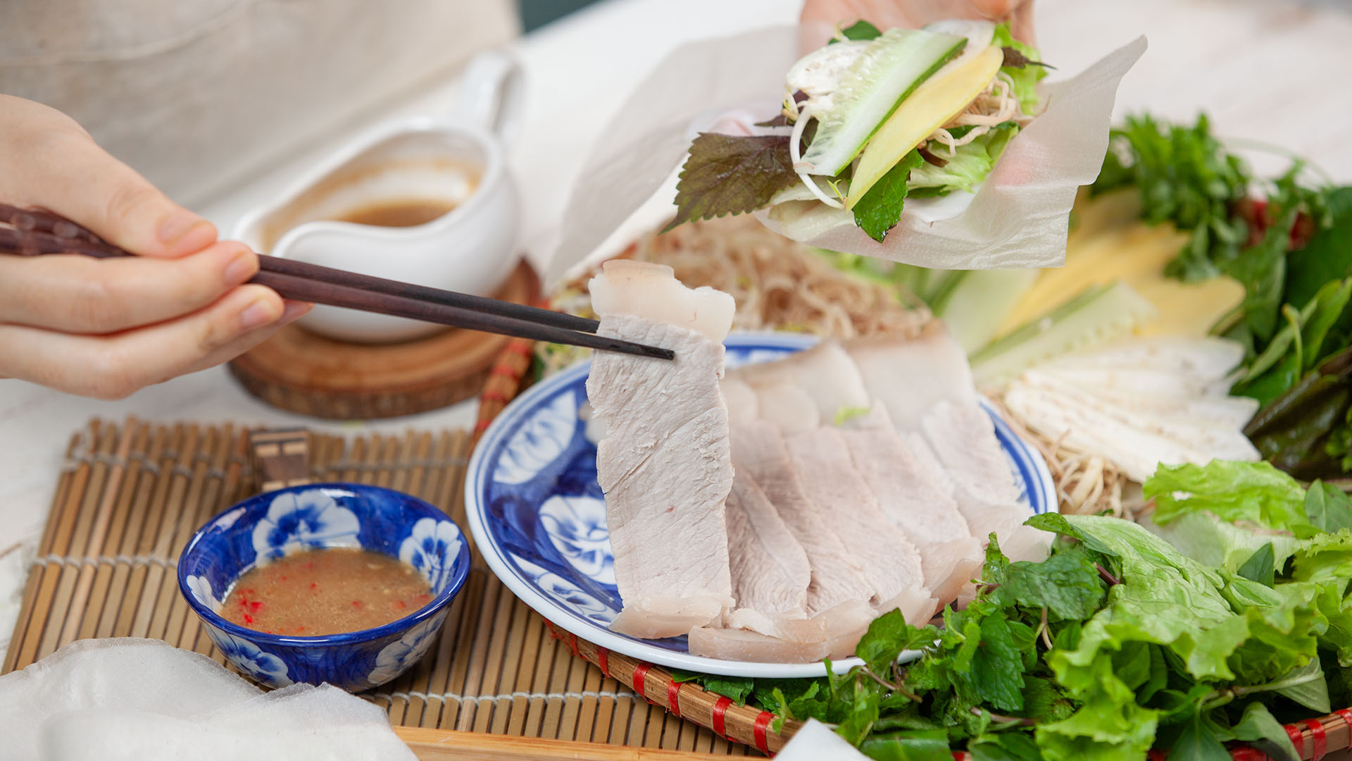 Bát mắm nêm đặc trưng miền Trung — màu vàng cam của dứa lên men, sợi cá cơm và lát ớt đỏ tươi — thứ nước chấm không thể thiếu của bánh tráng cuốn thịt heo