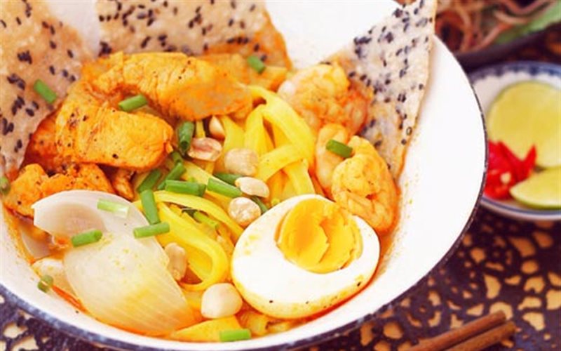 Cách cuốn nem lui tại bàn — tấm bánh tráng mỏng trải ra, đặt nem nướng và rau lên, cuốn nhanh tay rồi chấm ngay vào bát mắm nêm đặc sánh