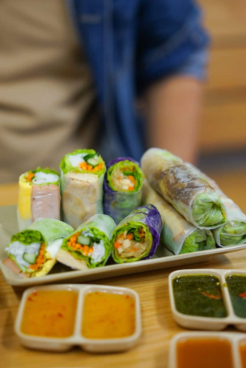 Chả giò vàng giòn vừa ra chảo, xếp trên đĩa lá chuối kèm rau sống và nước chấm — cách phục vụ truyền thống tại các quán gia đình