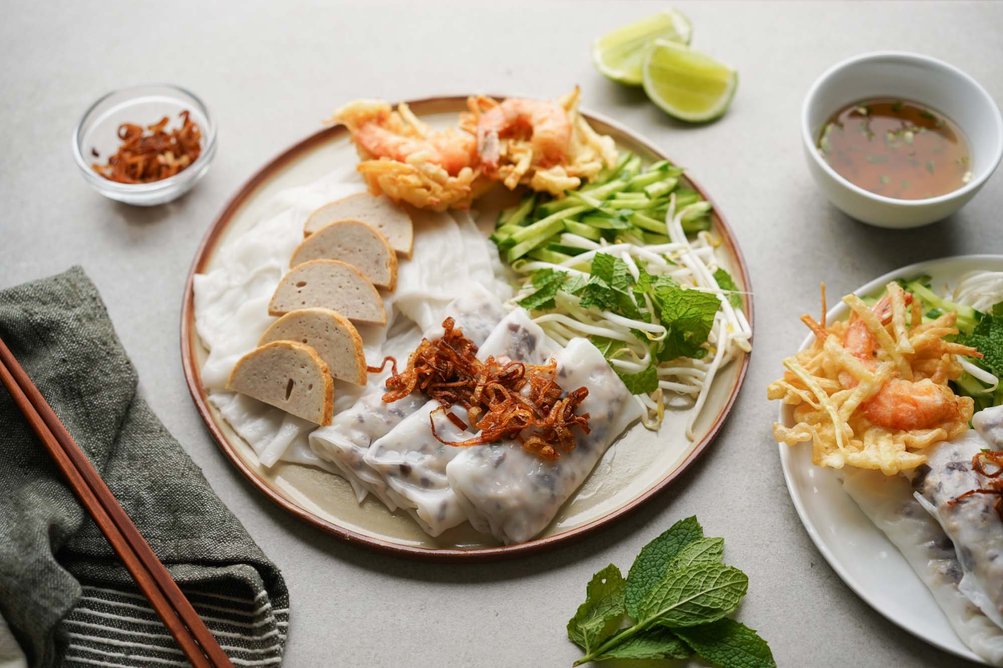 Đĩa bánh cuốn Hà Nội trắng ngần với lát giò lụa hồng, hành phi vàng và chén nước mắm trong vắt bên cạnh