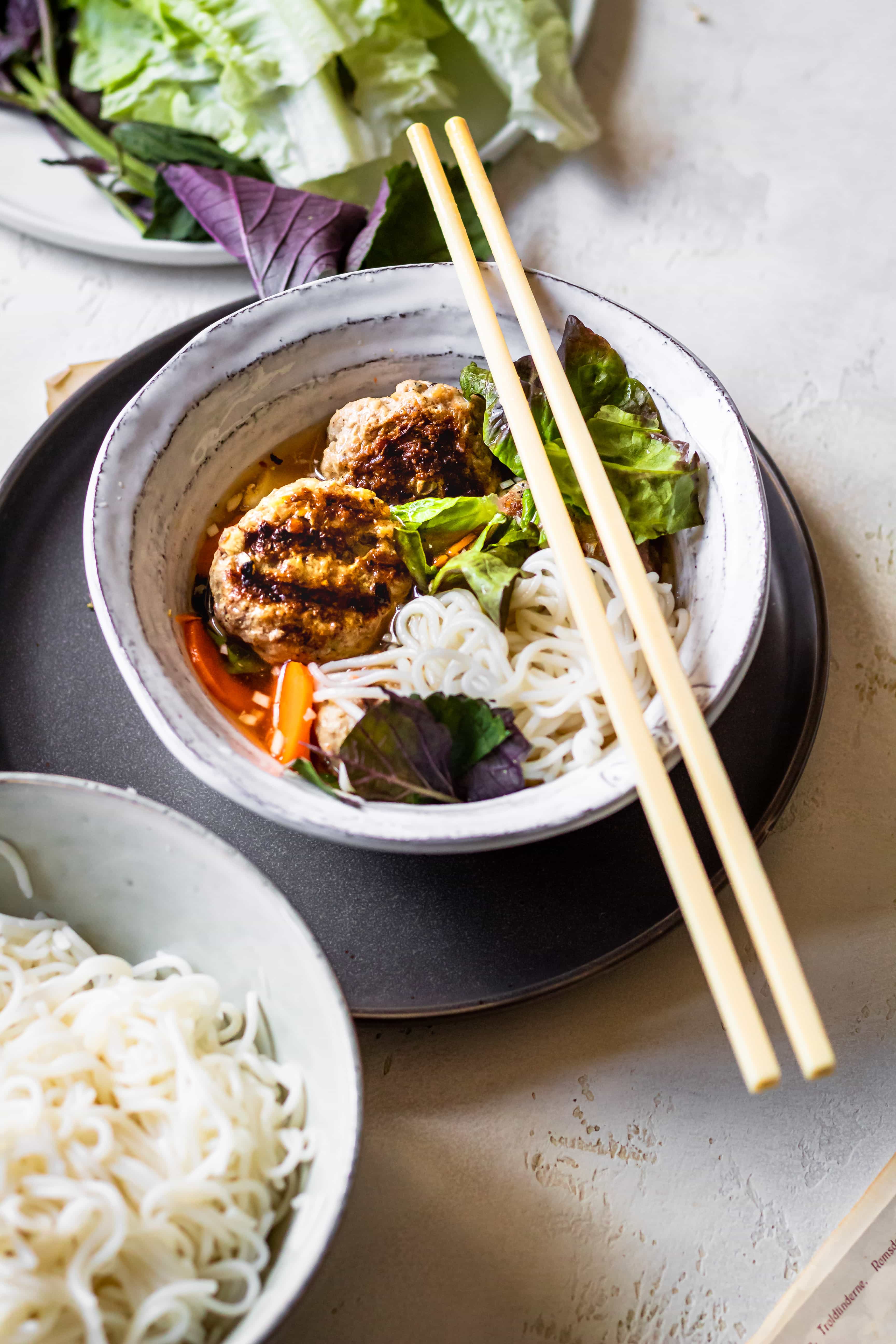 Người thợ nướng bún chả Hà Nội đang quạt than hoa với vỉ đầy chả thơm khói trên vỉa hè phố cổ