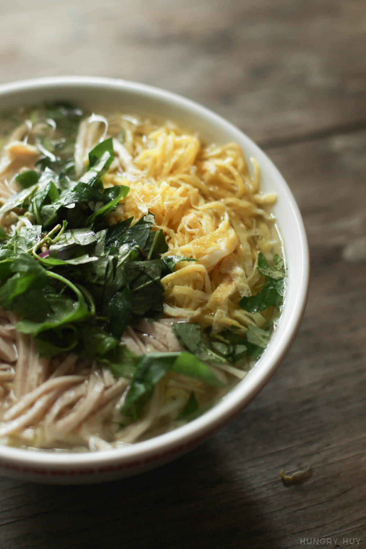Tô bún thang Hà Nội được bày trí nghệ thuật với thịt gà, chả lụa, trứng thái chỉ và rau răm xanh trên nền nước dùng trong vắt