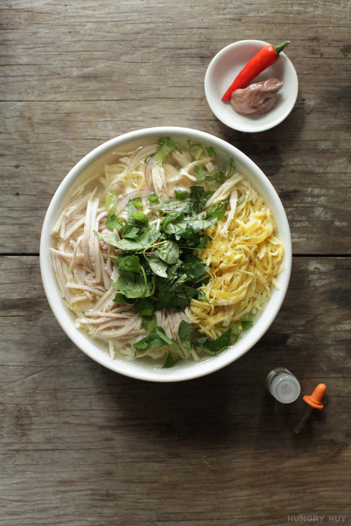 Quán bún thang Hà Nội truyền thống với hàng nguyên liệu bày gọn gàng và người phục vụ đang múc nước dùng gà trong vắt