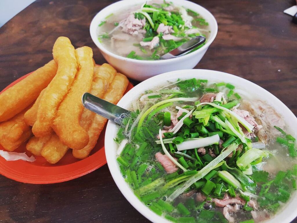 Bếp phở Hà Nội sáng sớm với nồi nước dùng xương bò hầm qua đêm đang bốc khói nghi ngút