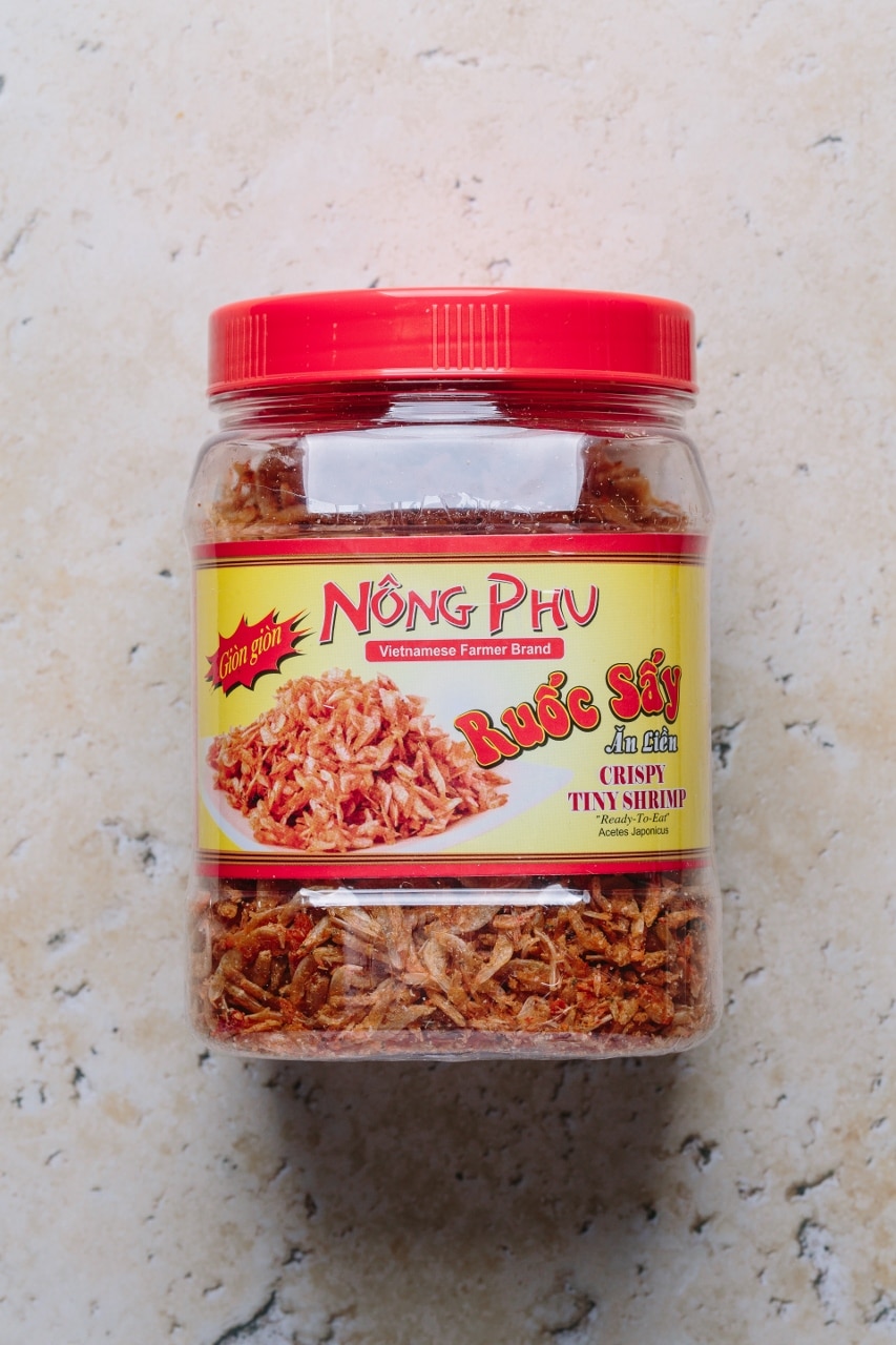 Túi bánh tráng trộn vừa được trộn xong với đầy đủ topping — xoài xanh, rau răm, trứng cút và khô bò, sẵn sàng để ăn tại chỗ
