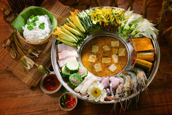 Mâm rau đồng tươi nguyên đặc trưng lẩu mắm miền Tây: bông súng, kèo nèo, bắp chuối bào và cà tím — những thứ chỉ có ở vùng sông nước
