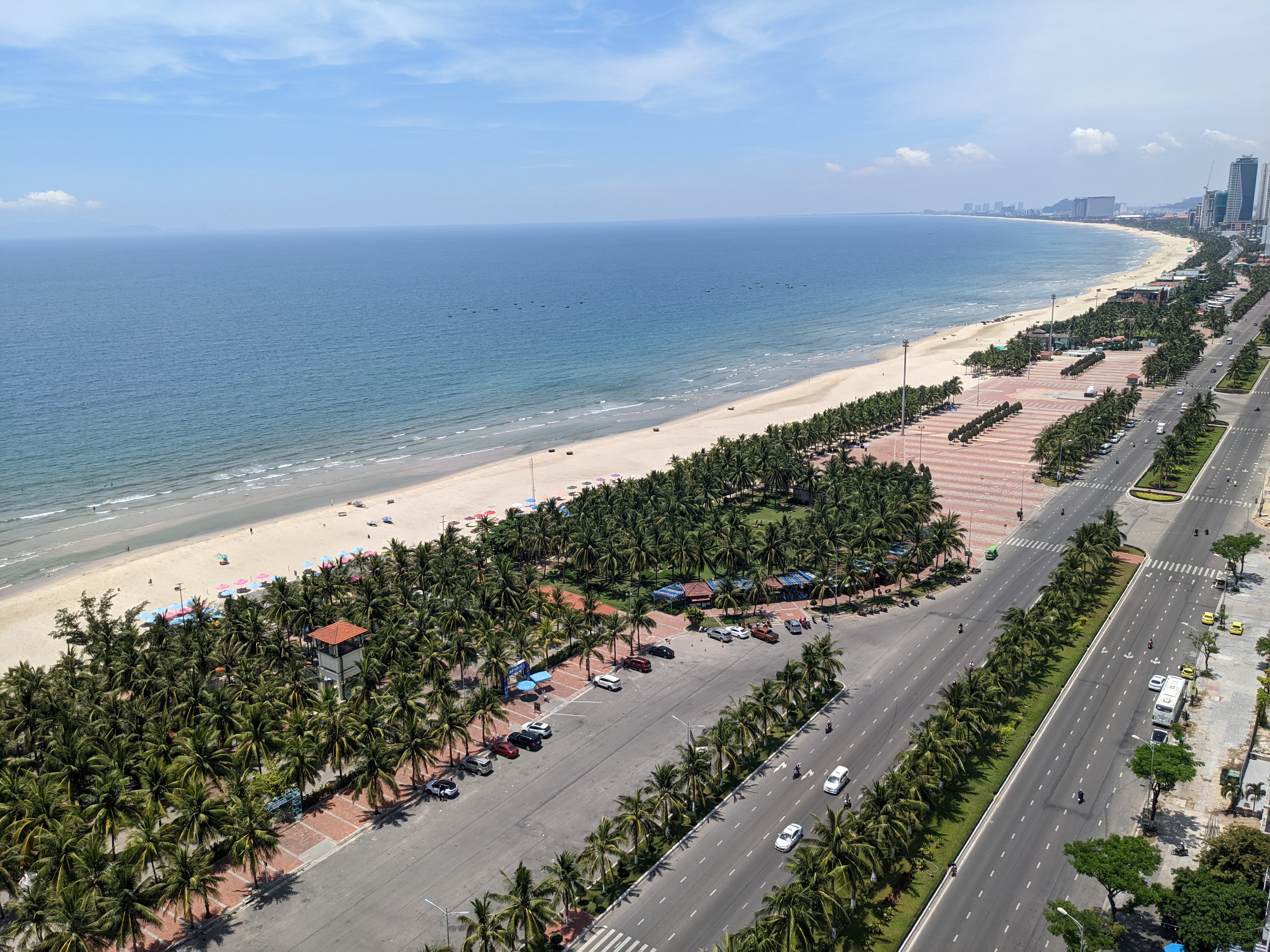 Hoàng hôn tại Mỹ Khê nhìn về phía cầu sông Hàn, bầu trời nhuộm cam và hồng phản chiếu xuống mặt biển