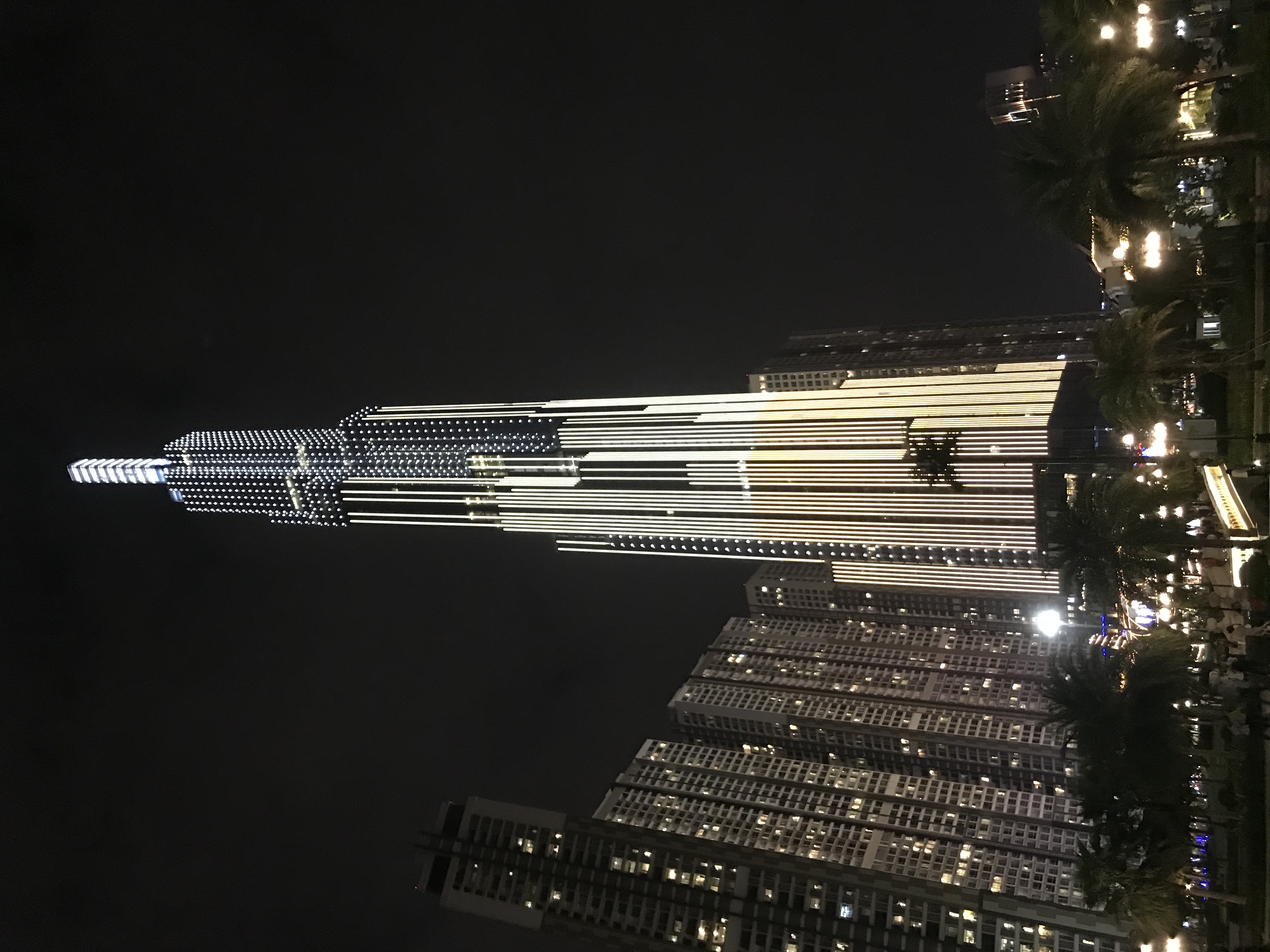 Landmark 81 nhìn từ bờ sông Sài Gòn lúc hoàng hôn — tòa tháp 461m phản chiếu ánh vàng cam của mặt trời lặn trên mặt kính bạc xanh