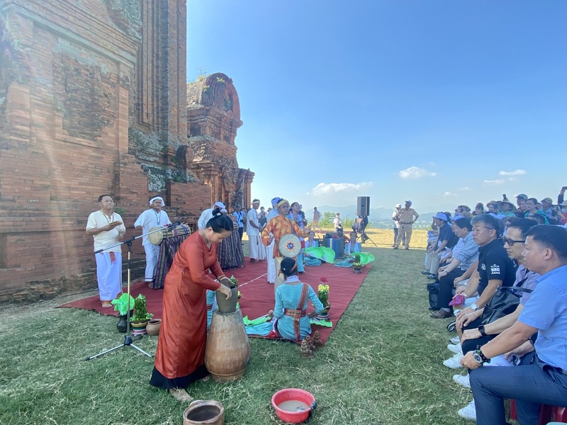 Người dân Quy Nhơn tản bộ quanh hồ Đôi vào buổi chiều, hai tháp đứng trên nền trời xanh