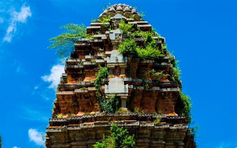 Tháp trung tâm Dương Long nhìn từ gần — khối gạch đỏ sẫm và đỉnh đá sa thạch vàng