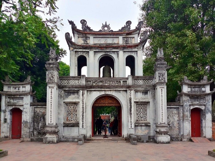Khuê Văn Các — biểu tượng của Văn Miếu xây năm 1805 dưới triều Gia Long — với tám cửa sổ tròn phản chiếu trên Giếng Thiên Quang và các bia tiến sĩ phía sau